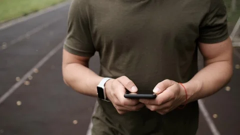 Man doing exercise and looking into smartphone during training. Stock Footage 113063109