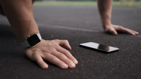 Man doing exercise and looking into smartphone on floor during training. Stock Footage 113064258