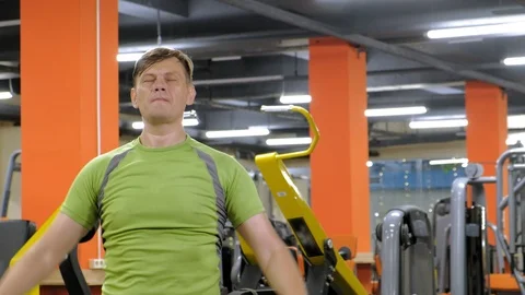 A man doing an exercise on the back delta with dumbbells sitting with a straight Video stock 111509472