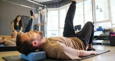 Man doing an exercise on the floor, lifting one leg during Pilates Stock Footage 305781660