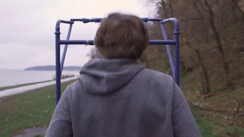 A man is doing an exercise on a horizontal bar in the street Stock Footage 82425754