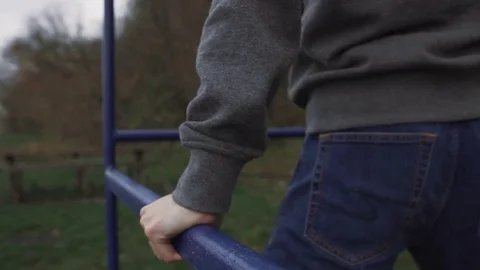 A man is doing an exercise on a horizontal bar in the street Stock Footage 82425755