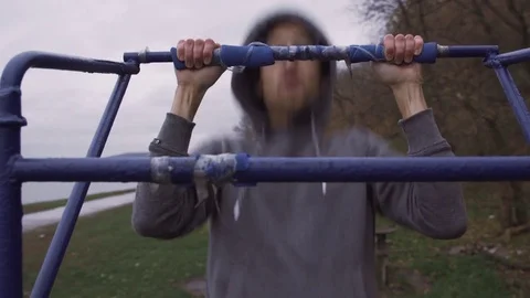 A man is doing an exercise on a horizontal bar in the street Stock Footage 82425764