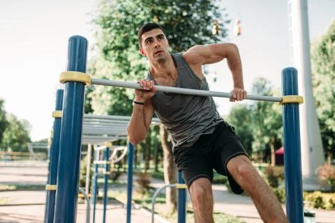 Man doing exercise on horizontal bar outdoor Stock-Fotos
