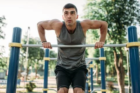 Man doing exercise on horizontal bar outdoor 스톡 사진