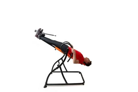 Man doing exercise on inversion table for his back pain, isolated on white Stock Photos