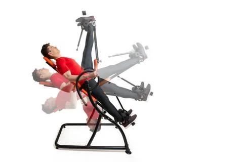 Man doing exercise on inversion table for his back pain, isolated on white Stock Photos