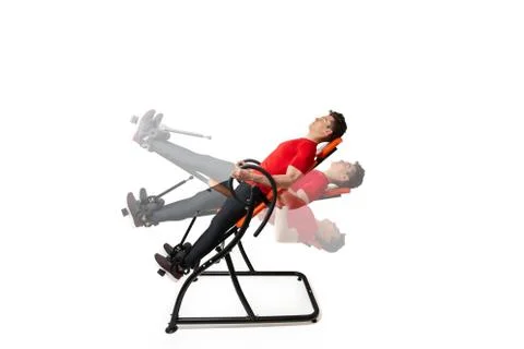 Man doing exercise on inversion table for his back pain, isolated on white Stock Photos
