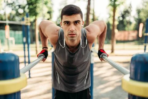 Man doing exercise on parallel bars, front view Stock Photos