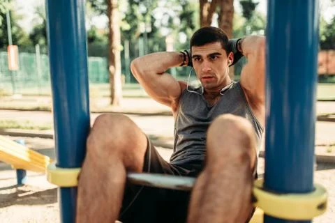 Man doing exercise on press outdoor, back view Stock Photos