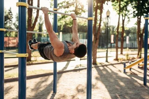Man doing exercise on press using horizontal bar 스톡 사진