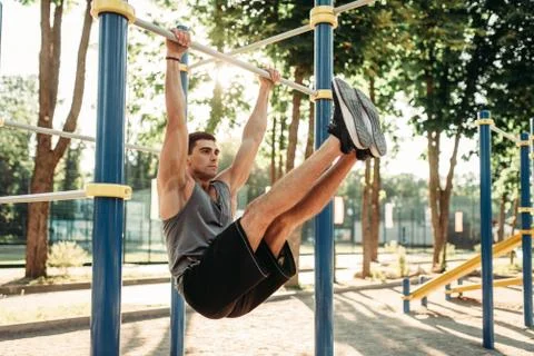 Man doing exercise on press using horizontal bar Stock-Fotos