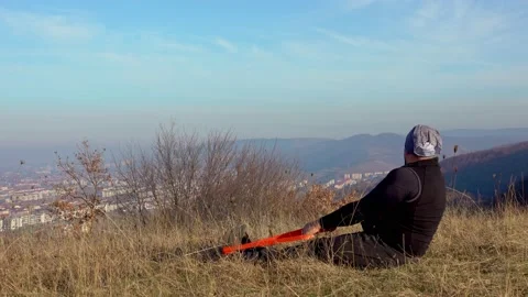 Man Doing Exercise With Rubber Band On Meadow Near City Stockbeeldmateriaal 165098866