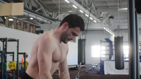 Man is doing exercise for triceps pulling rope on cable row crossover machine. Video stock 234549211