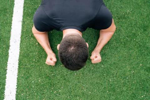 A man is doing an exercise while lying down. Sport on green grass Stock Photos