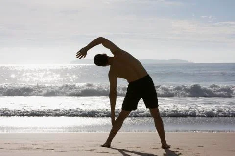 Man doing exercises on beach Stock Photos