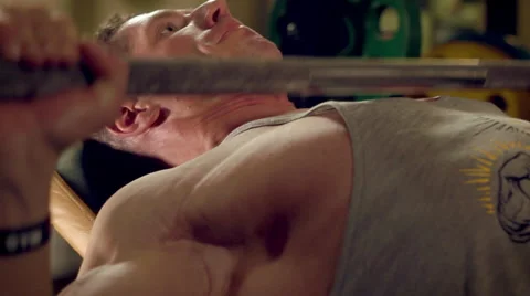 Man doing exercises bench press with a barbell in the gym close-up Stock Footage 63052217