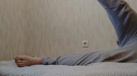 Man doing exercises in gray pants on a mattress Stock Footage 196969502