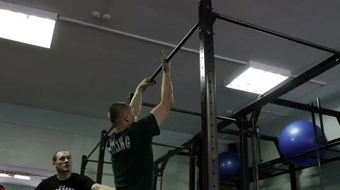 Man doing exercises on the horizontal bar in the gym Stock Footage 62366031