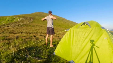 Man doing exercises near mountain camp. Slowmo 스톡 동영상 211099398