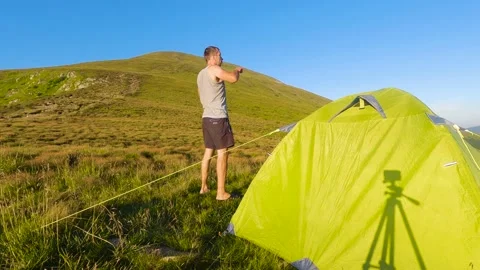 Man doing exercises near mountain camp. Slowmo 스톡 동영상 211099631
