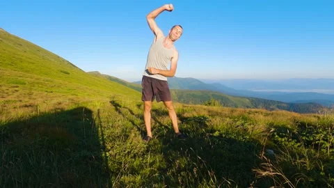 Man doing exercises near mountain. Slowmo 스톡 동영상 211099703