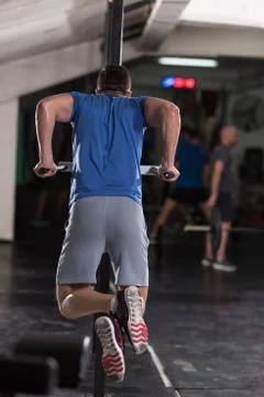 Man doing exercises parallel bars Stock Photos