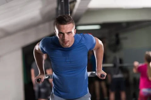 Man doing exercises parallel bars Stock Photos