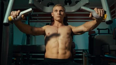 Man doing exercises on the simulator Stock Photos