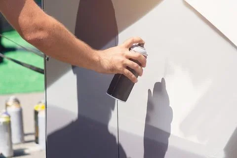 Man doing graffiti, holding spray can with hand. Spray aerosol paint Stock Photos
