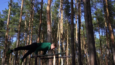 Man doing gymnastic on the parallel bars in the forest. Healthy lifestyle Stock-Footage 148702175