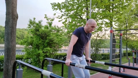 Man doing gymnastics on parallel bars Stockbeeldmateriaal 195937613