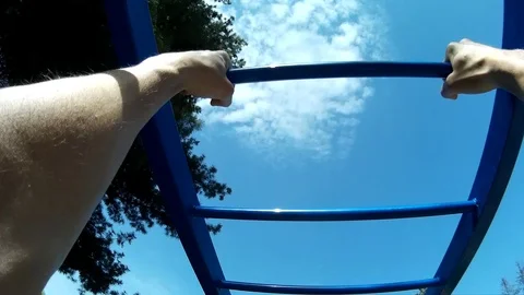 Man doing gymnastics in park on pull-up bar, bracing himself POV Stock Footage 75263166