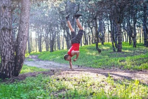 Man doing a handstand on a forest path, free space. Foto stock