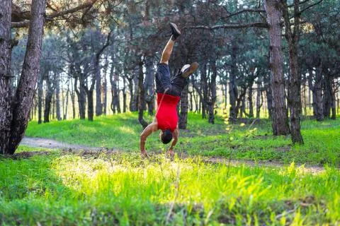 Man doing a handstand on a forest path, free space. Stock-Fotos