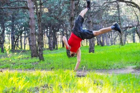 Man doing a handstand on a forest path, free space. Stock Photos