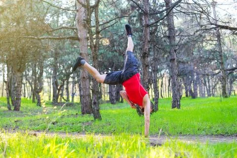 Man doing a handstand on a forest path, free space. Stock Photos