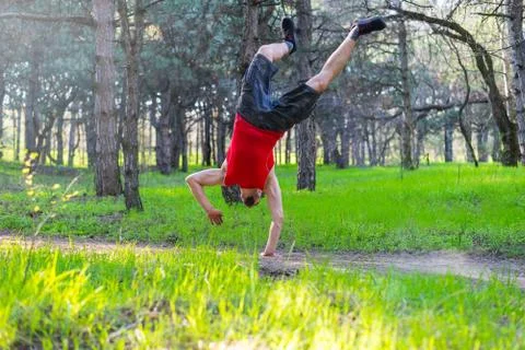 Man doing a handstand on a forest path, free space. Stock Photos