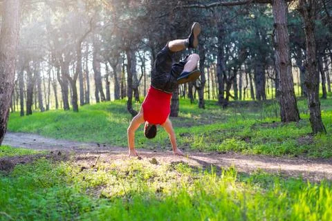 Man doing a handstand on a forest path, free space. Stock Photos