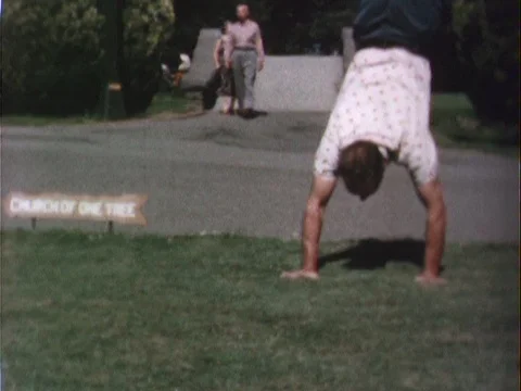 Man doing a handstand in the park and running offscreen Stock Footage 79271251