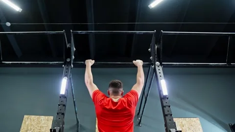Man doing hanging pull ups in gym. Fitness man training indoors. Stock Footage 273200490