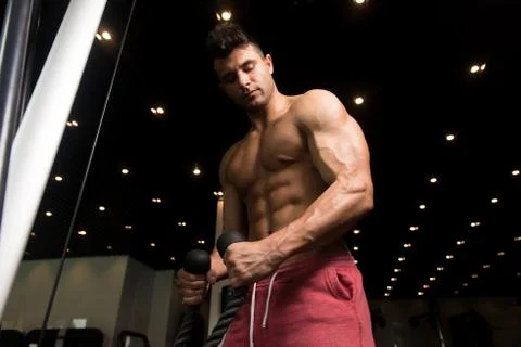 Man Doing Heavy Exercise For Biceps With Cable Stock Photos