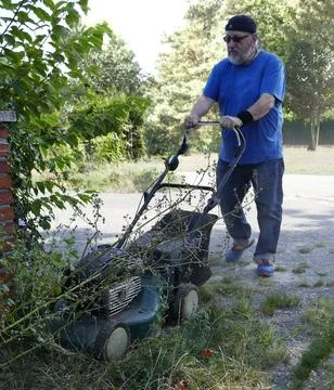 A man doing his duty: mowing grass Stock Photos