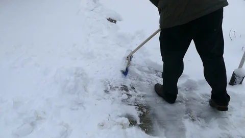 A man doing his job cleaning the snow with a brush Stock Footage 100891649
