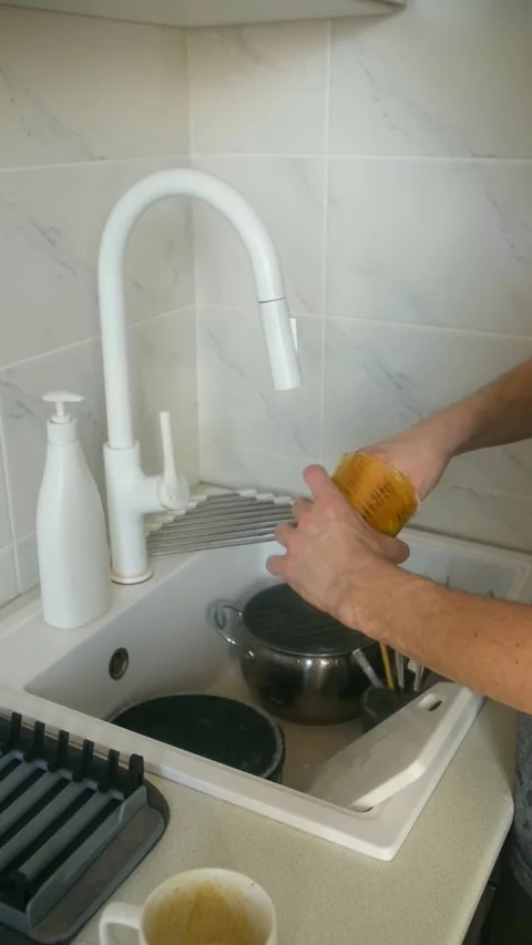 Man doing housework washing dishes in kitchen sink 動画素材 337830967