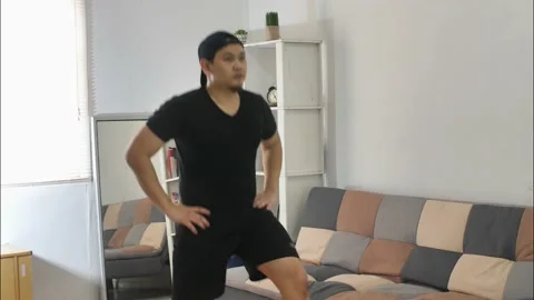 Man doing indoor home workout, legs lower body body weight training Stock Footage 140119771