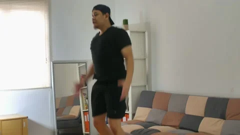 Man doing indoor home workout, jumping jacks Stock Footage 140119806