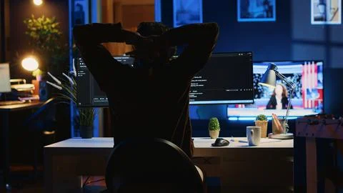 Man doing IT support job from home office, stretching after sitting at desk Foto stock
