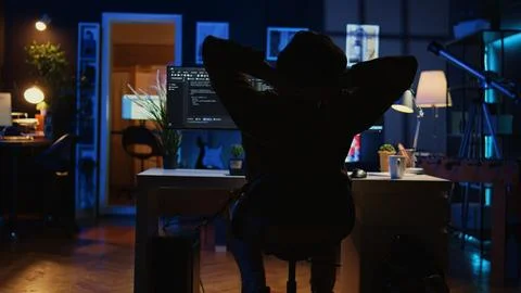 Man doing IT support job from home office, stretching after sitting at desk 写真素材