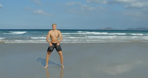 A man doing Kettelbell Swings on a beach whilst Crossfit training. Vídeo Stock 85511906